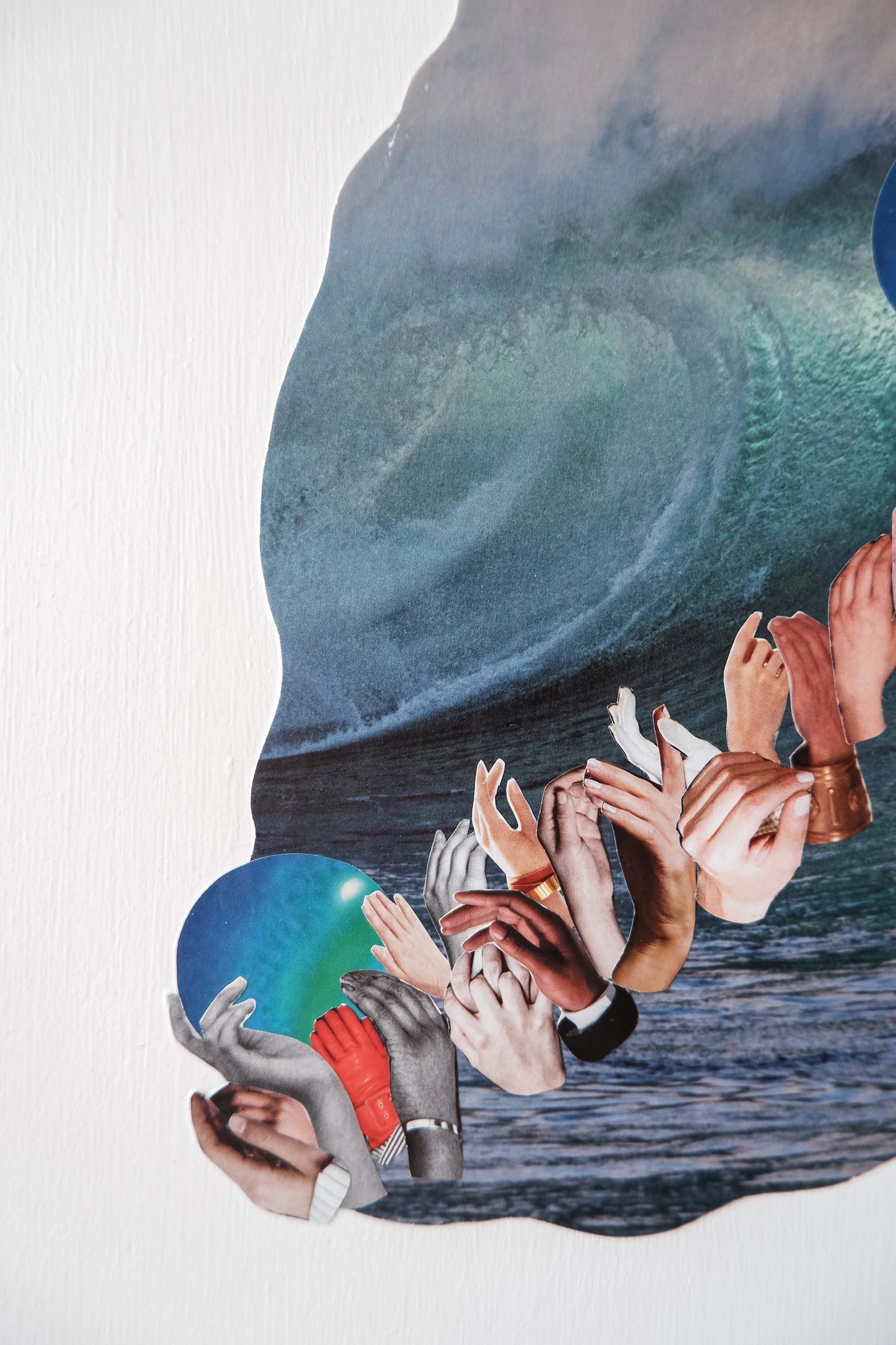 close up of Three Waves collage art, shows vertical paint texture of white background and details of images of diverse hands and neptune