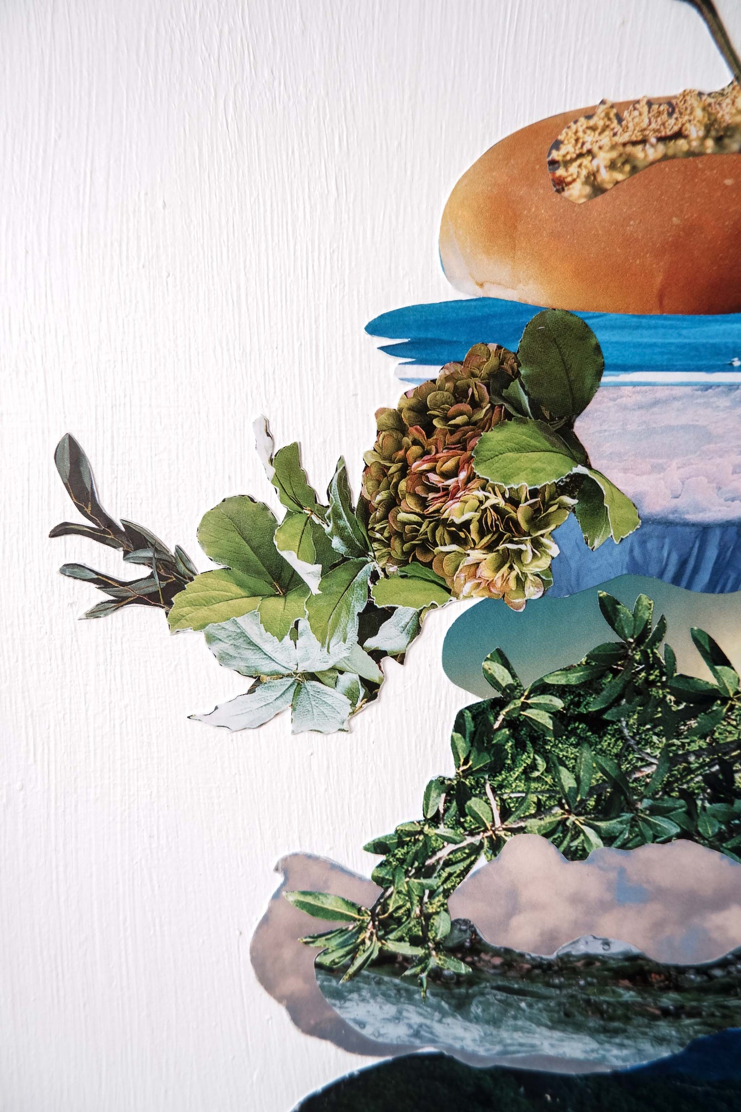 close up of Botanical Burger collage art, shows vertical paint texture of white background and details of images of water, plants, flowers and sky.
