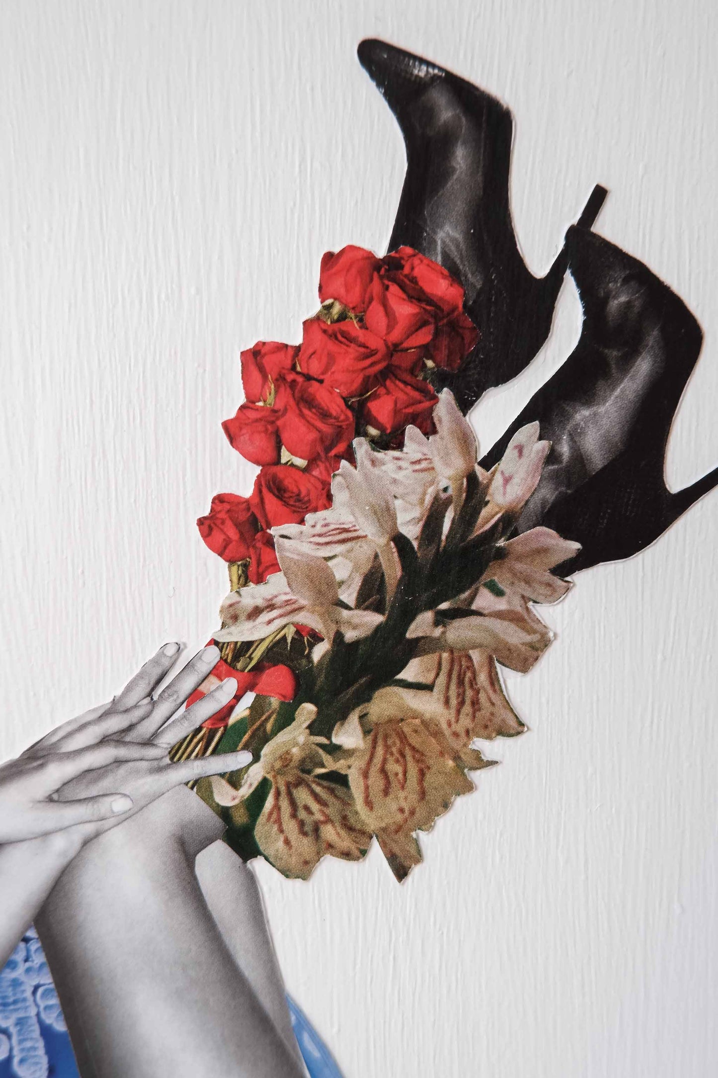 close up of Botanical Ink collage art, shows vertical paint texture of white background and details of images hands, black leather heeled boots adorned with red and white flower bouquets 