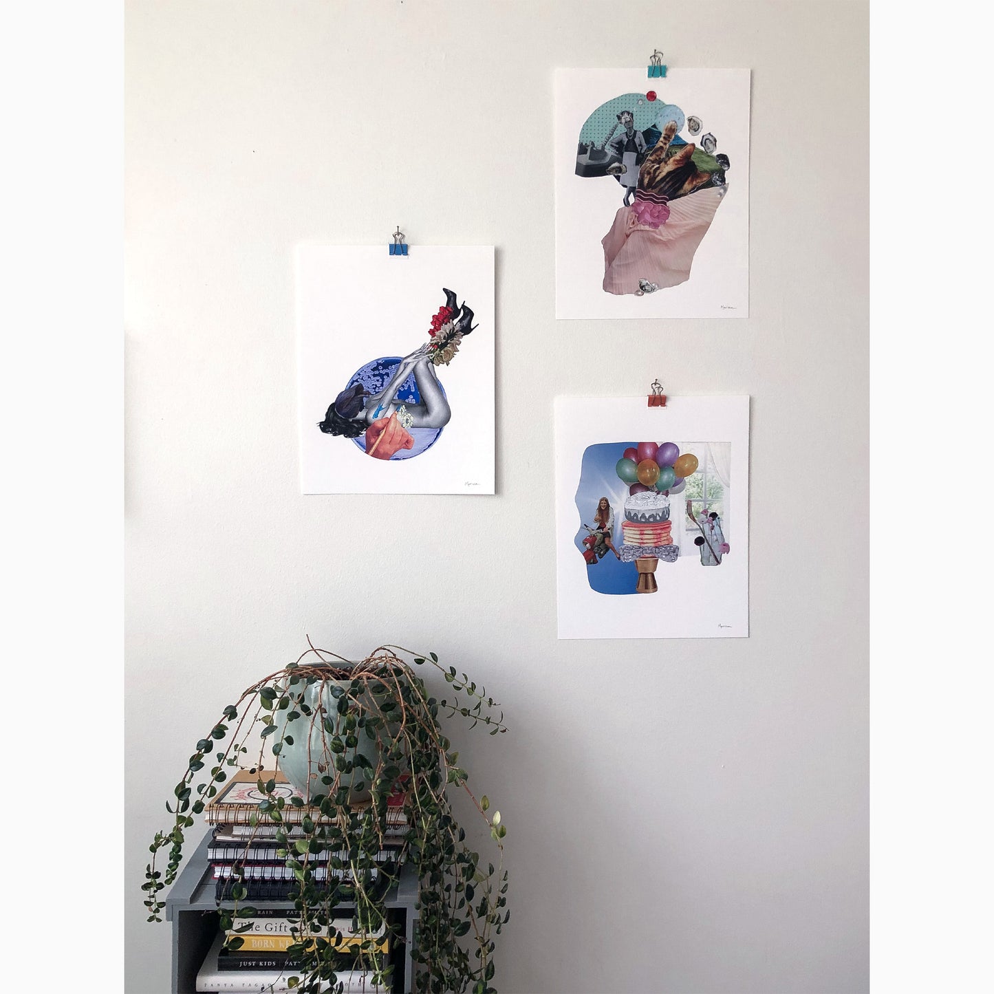 gallery wall of whimsical fina art prints, plant hangs off a book of shelves